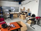 a room that has a table, chairs, and a workbench in it