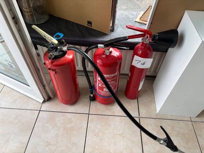 two fire extinguisors on the floor next to a door
