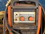 an orange and black welding machine sitting on top of a table