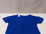 the children ' s blue t - shirt is laying on a white surface