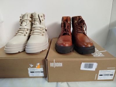 trois paires de bottes pour homme posées sur une boîte en carton