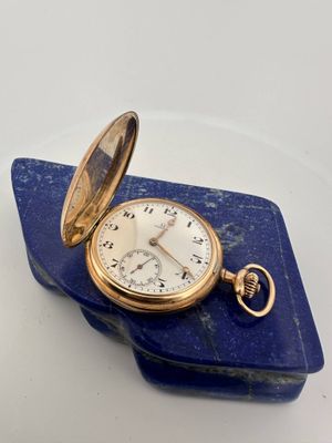 an image of a pocket watch sitting on top of a blue piece of paper