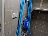 a blue hose attached to a wall in a bathroom