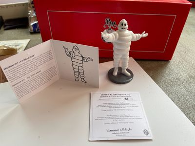 une petite figurine représentant un homme, les deux mains posées sur une table