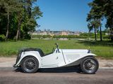 a white vintage car parked on the side of the road