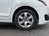 a small white car parked on the side of the road
