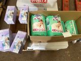 des cartons de couches et de lingettes posés par terre à côté de cartons de papier toilette