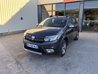 une Dacia noire garée devant un immeuble