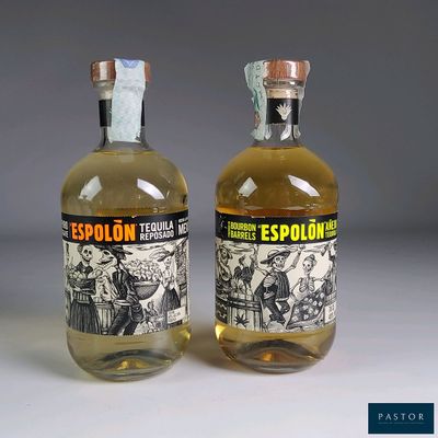 two bottles of liquor sitting next to each other on top of a table