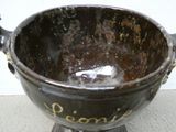 a black bowl with writing on it sitting on a stand