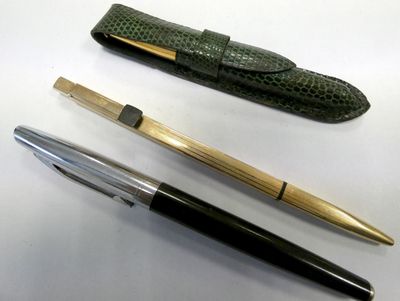 two pens and a pen case sitting on a table