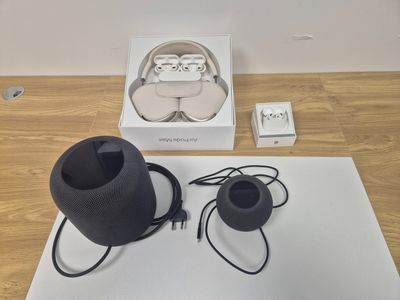 a black speaker sitting on top of a table next to a white box