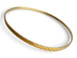 un gros plan d'un bracelet rigide en or sur fond blanc