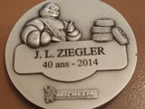 une médaille d'argent sur laquelle figure l'image d'un homme tenant une raquette de tennis
