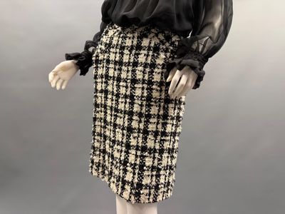 a mannequin wearing a skirt and blouse with a black blouse