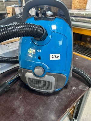 un aspirateur bleu posé sur une table