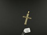 a gold cross pendant with a price tag on a black background