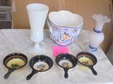 several bowls and spoons are sitting on a table with a vase in the background