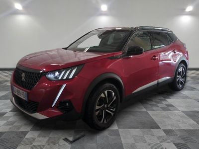 Le SUV rouge est garé sur un sol à damier dans un garage.