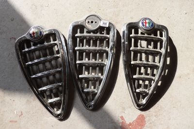 Deux paires de chaussures noires et chromées sont posées sur une surface en béton.