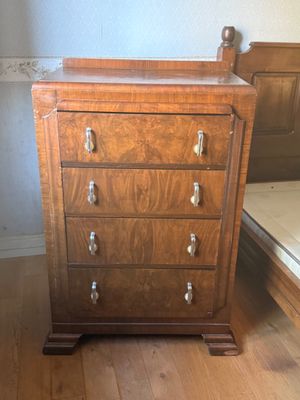 a wooden chest of drawers in the corner of a room