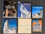 plusieurs livres posés sur un tapis, avec un bâtiment en arrière-plan
