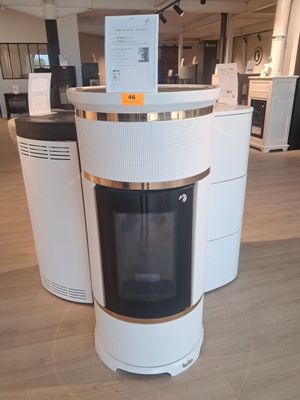 une photo d'un poêle blanc et doré dans un magasin