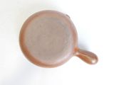 a brown cup sitting on a white surface