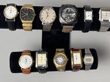 cinq montres différentes exposées sur un présentoir noir