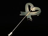 a silver brooch with a heart shaped pin on it