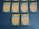 six magic the gathering card game tokens sitting on top of a table