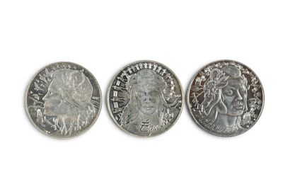 three different types of silver coins on a white surface