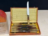 a box with a knife and a box of knives on a table