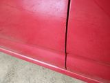 a red car that has a crack in the side of it