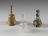 trois types différents d'objets en verre et en laiton posés sur une surface blanche