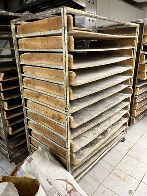 de nombreux plateaux en bois empilés les uns sur les autres dans une pièce