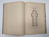 an open book with a cross drawn on it sitting on top of a table