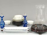 une table sur laquelle se trouvent un vase, des assiettes, des tasses et d'autres objets
