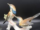 deux figurines d'oiseaux perchés sur une branche