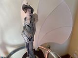 a figurine of a woman with an umbrella on a glass table