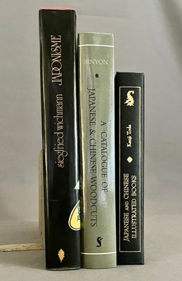 trois livres posés l'un à côté de l'autre sur une table