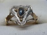 l'image d'une bague contenant une pierre bleue