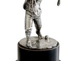 statue d'un homme tenant un club de golf, posée sur un socle noir