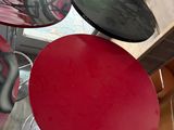 four different colored stools in a room with wood floors