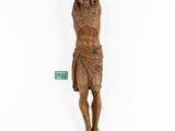 a wooden statue of jesus hanging on the wall