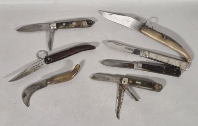 many different types of knives on a white surface