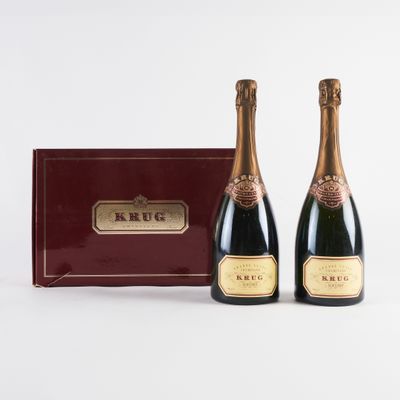 deux bouteilles de champagne devant une boîte rouge