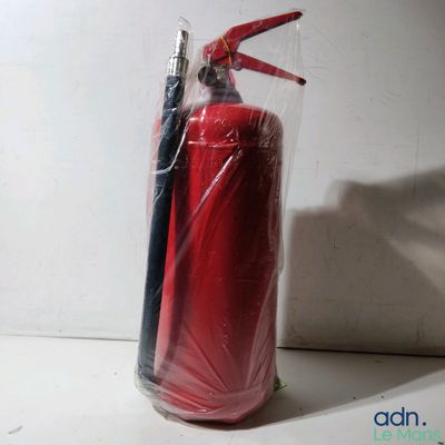 un extincteur rouge et un stylo noir dans un sac transparent