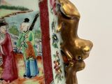 a vase with a painting on it sitting on a table