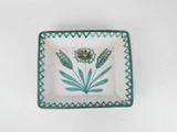 an image of a green and white plate with a flower design on it
